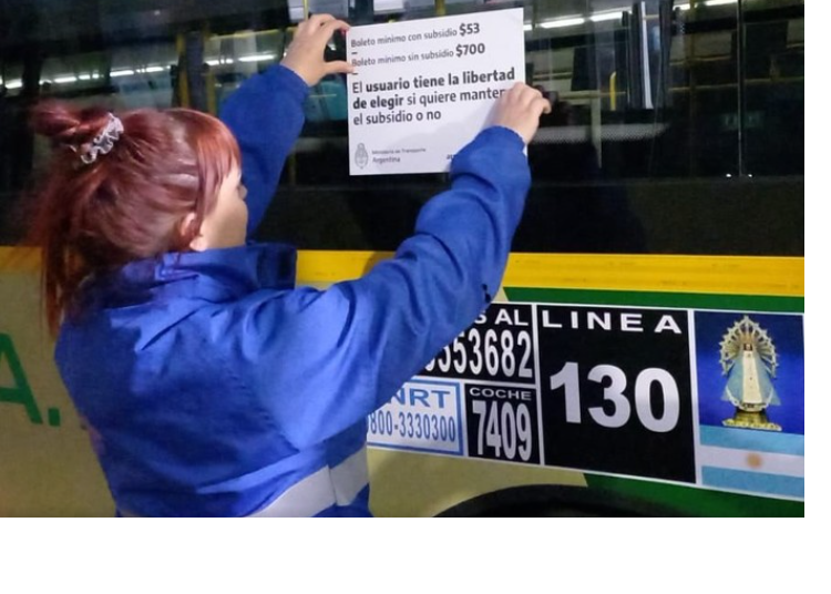 Funcionarios del Gobierno poniendo carteles en los colectivos para la campaña de los subsidios que impulsa Massa.png